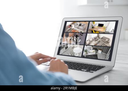 Frau überwacht Überwachungskameras am Tisch, Nahaufnahme. Intelligentes Sicherheitssystem für Ihr Zuhause Stockfoto