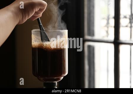 Der Barista bereitet Kaffee mit der Vakuummaschine im Café zu. Platz für Text Stockfoto