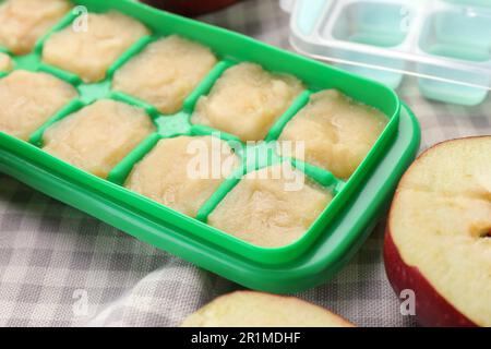 Apfelpüree in Eiswürfelschale mit Zutaten auf dem Tisch, Nahaufnahme Stockfoto