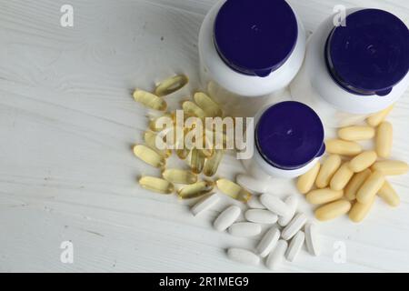 Medizinische Flaschen und Pillen auf weißem Holztisch, über Sicht. Platz für Text Stockfoto