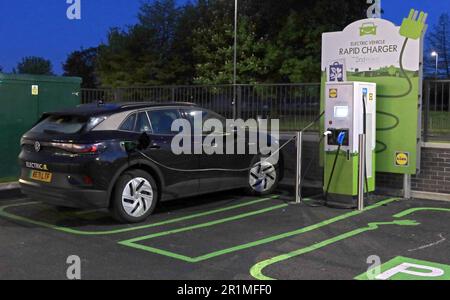 Lidl PodPoint, Ladegerät in Verwendung mit VW Volkswagen Electric, Liverpool, Merseyside, England, Großbritannien, L36 3YD Uhr nachts Stockfoto