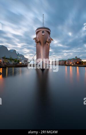 NORFOLK, VIRGINIA, USA - 10. MAI 2023: Die USS Wisconsin (BB-64) befindet sich in der Abenddämmerung im maritimen Museum Nauticus. Stockfoto