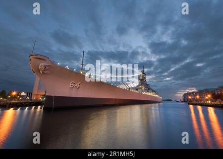 NORFOLK, VIRGINIA, USA - 10. MAI 2023: Die USS Wisconsin (BB-64) befindet sich in der Abenddämmerung im maritimen Museum Nauticus. Stockfoto