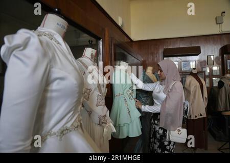 (230515) -- KAIRO, 15. Mai 2023 (Xinhua) -- Eine Frau besucht eine Ausstellung von Kleidung und Accessoires während der ersten Ausgabe der Egypt Fashion Week in Kairo, Ägypten, 13. Mai 2023. In der ersten Ausgabe der Egypt Fashion Week, einer viertägigen Veranstaltung, die am Freitag begann, präsentierten mehr als 70 ägyptische Designer ihre Kollektionen auf und abseits der Laufbahn. Die Veranstaltung, die vom Egyptian Fashion and Design Council (EFDC) unter der Schirmherrschaft des ägyptischen Ministeriums für Planung und wirtschaftliche Entwicklung, des Ministeriums für Tourismus und Antiquitäten und des Ministeriums für Landwirtschaft und Bodengewinnung organisiert wird, ist Stockfoto