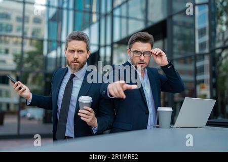 Ausdrucksgesicht eines emotionalen Geschäftsmannes. Ein seriöser Geschäftsmann, der mit dem Finger auf Sie zeigt. Porträt eines Geschäftsmannes im Anzug im Freien. Die Partnerschaft Stockfoto