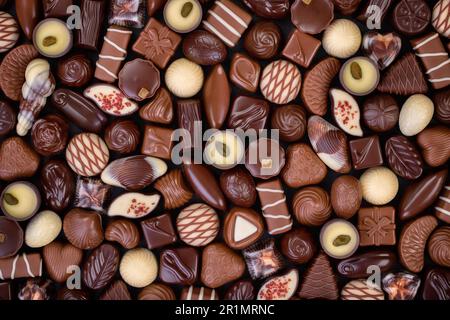 Mischen Sie Schokoladenbonbons und andere Konfekt, süßer Hintergrund. Stockfoto