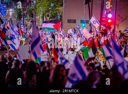 Tel Aviv, Israel. 13. Mai 2023. Demonstranten halten während eines Protests gegen den Krieg und die Justizreform die israelische und palästinensische Flagge. Israel und der Islamische Dschihad stimmten einem Waffenstillstand am Samstag zu, nach Tagen der Gewalt, die mindestens 34 Palästinenser und einen Israeli das Leben gekostet haben. (Foto: Eyal Warshavsky/SOPA Images/Sipa USA) Guthaben: SIPA USA/Alamy Live News Stockfoto