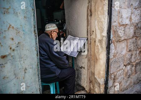 Nablus, Palästina. 14. Mai 2023. Ein alter Palästinenser liest den Koran in seinem Haus in der Altstadt von Nablus, nördlich des besetzten Westjordanlands. (Foto von Nasser Ishtayeh/SOPA Images/Sipa USA) Guthaben: SIPA USA/Alamy Live News Stockfoto