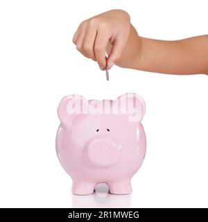 Jeder Penny zählt. Eine Person, die eine Münze in eine Sparbank steckt. Stockfoto