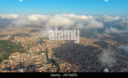 Hubschrauber über die Luftdrohne Barcelona City über den Wolken und Nebel, Basilika Sagrada Familia und das berühmte städtische Netz von Eixample. Katalonien, Spanien Stockfoto