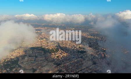 Hubschrauber über die Luftdrohne Barcelona City über den Wolken und Nebel, Basilika Sagrada Familia und das berühmte städtische Netz von Eixample. Katalonien, Spanien Stockfoto