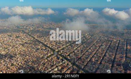 Hubschrauber über die Luftdrohne Barcelona City über den Wolken und Nebel, Basilika Sagrada Familia und das berühmte städtische Netz von Eixample. Katalonien, Spanien Stockfoto