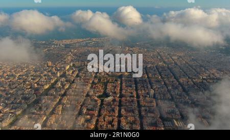 Hubschrauber über die Luftdrohne Barcelona City über den Wolken und Nebel, Basilika Sagrada Familia und das berühmte städtische Netz von Eixample. Katalonien, Spanien Stockfoto