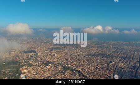 Hubschrauber über die Luftdrohne Barcelona City über den Wolken und Nebel, Basilika Sagrada Familia und das berühmte städtische Netz von Eixample. Katalonien, Spanien Stockfoto