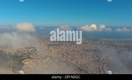 Hubschrauber über die Luftdrohne Barcelona City über den Wolken und Nebel, Basilika Sagrada Familia und das berühmte städtische Netz von Eixample. Katalonien, Spanien Stockfoto