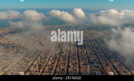 Hubschrauber über die Luftdrohne Barcelona City über den Wolken und Nebel, Basilika Sagrada Familia und das berühmte städtische Netz von Eixample. Katalonien, Spanien Stockfoto