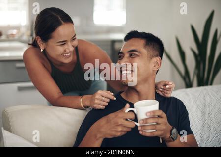 Danke, Liebling, für diese perfekte Tasse Kaffee. Ein junges Paar, das Kaffee trinkt, während es sich zu Hause entspannt. Stockfoto