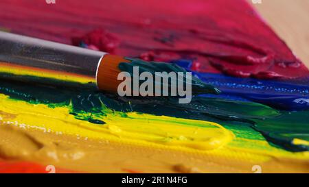 Pinsel auf Künstlerpalette mit bunten Farben, Nahaufnahme Stockfoto