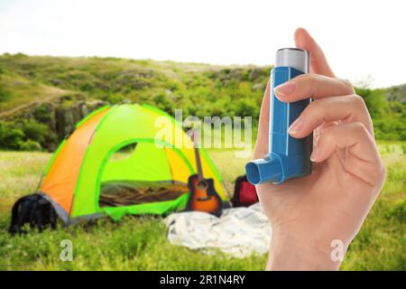 Junge Frau, die draußen an einem sonnigen Tag Asthmainhalator benutzt, Nahaufnahme. Erste Notfallhilfe bei Freizeitaktivitäten im Freien Stockfoto