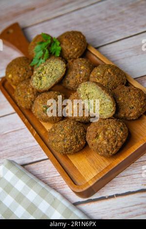 Falafel-Kugeln auf einem Holzbrett und Tahini-Sauce Stockfoto