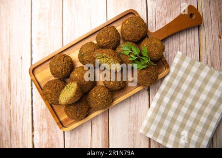 Falafel-Kugeln auf einem Holzbrett und Tahini-Sauce Stockfoto