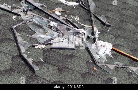 Kaputtes Dach nach einem Sturm. Ein großes Gebäude mit einem beschädigten Dach nach einem starken Hurrikan mit zerbrochenem Glas und Fensterrahmen Stockfoto