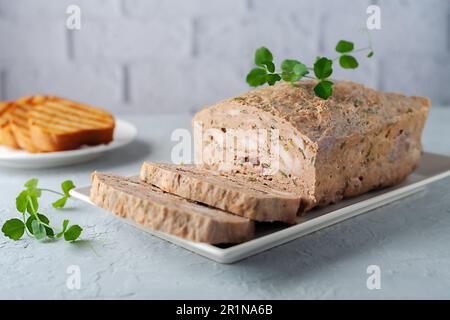 Hühnerterrine. Hähnchenfleischpastete mit frischer Petersilie Stockfoto