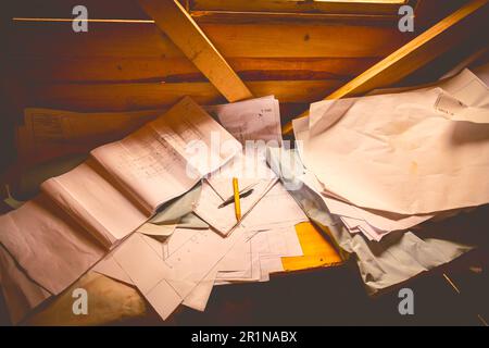 Masons Schreibtisch in einer Holzkabine mit einem Stapel architektonischer Zeichnungen, Papierlayouts und Plänen. Stockfoto