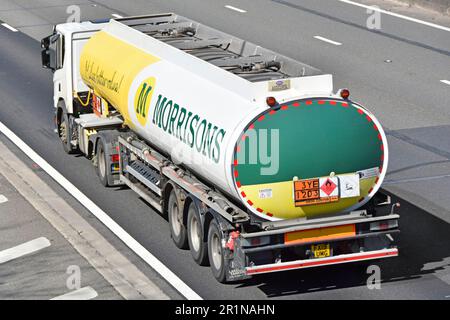 Seitenansicht hinten hinten – Volvo lkw-Triebwerk für Lastkraftwagen und Morrisons Supermarkt – Kraftstofflieferung in knickgelenktem Auflieger – Warnschild für Chemikalien (GB) Stockfoto