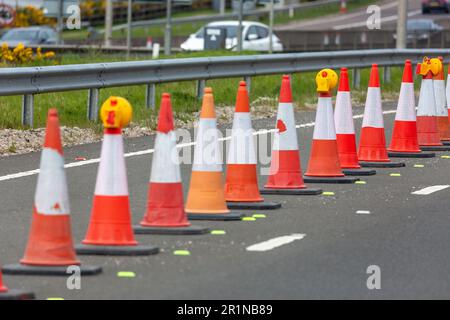 Orangefarbene Verkehrskegel auf einer Straße in Fife, Schottland Stockfoto