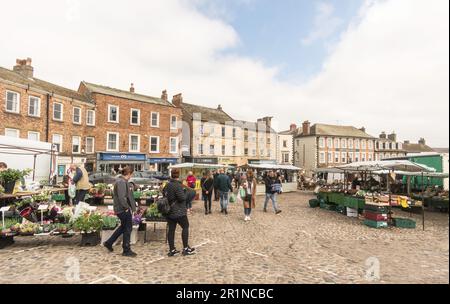 Leute, die in Richmond Outdoor Market, Market Place, Richmond, North Yorkshire, England einkaufen, UK Stockfoto