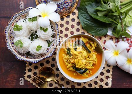 Thai Crab Curry und Betel Leave in Benjarong Porzellan mit Reis Vermicelli auf Holzhintergrund - Curry im Phuket-Stil namens Kang Poo Stockfoto