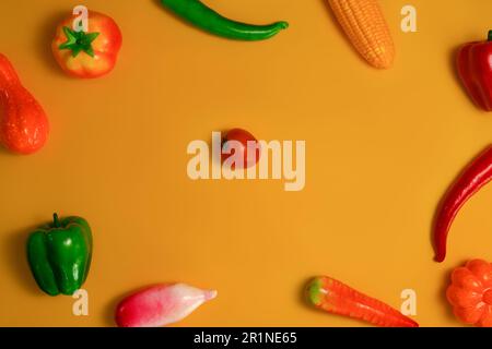 Farbenfrohes Gemüse auf orangefarbenem Hintergrund, gesundes Essen im Hintergrund, vegetarisches Speisekonzept Stockfoto