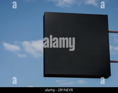 Unbedruckte Schilder im Schaufenster. Löschen Sie die Werkstattvorlage. Die Straße hängt an der Wand. Schild für Logo-Präsentation. Café-Restaurant aus Metall Stockfoto