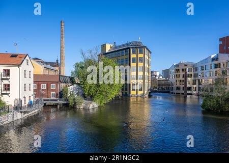 Motala River und das berühmte Flatiron Gebäude in der alten Industrielandschaft im Frühling in Norrköping. Stockfoto