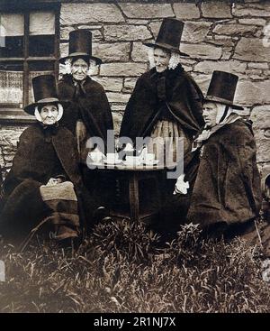 Ein altes Bild von vier walisischen Frauen im Nationalkleid von Wales, die 1939 Nachmittagstee tranken. Stockfoto