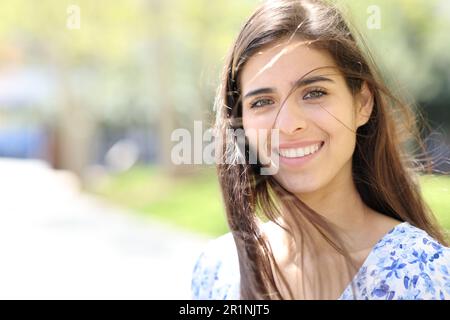 Eine glückliche Frau mit faulen Haaren sieht dich auf der Straße an Stockfoto