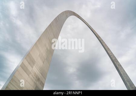 Der Gateway Arch schwingt sich über einen dramatischen bewölkten Himmel, sein rostfreier Stahlbeinständer neigt sich von der linken Unterseite herein, Gateway Arch National Park, Missouri. Stockfoto