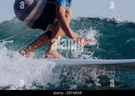 Nahaufnahme von Surferbeinen auf einem Surfbrett Stockfoto