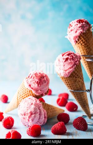 Eiscreme mit Himbeere in Waffel auf blauem Hintergrund Stockfoto