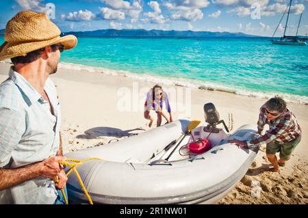 Ich ziehe ein Schlauchboot am Strand hoch. Stockfoto