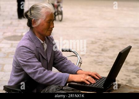 Alte chinesische Frau auf Laptop-Computer in Shanghai China Stockfoto