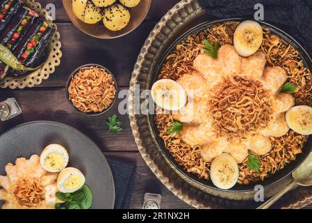 Ägyptische Küche; ägyptisches traditionelles Gericht 'Alexandrian Koshary'. Es besteht aus Orangenlinsen und Reis. Serviert mit eingelegter Aubergine und Zitrone. Stockfoto