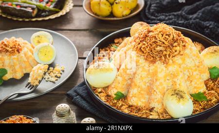 Ägyptische Küche; ägyptisches traditionelles Gericht 'Alexandrian Koshary'. Es besteht aus Orangenlinsen und Reis. Serviert mit eingelegter Aubergine und Zitrone. Stockfoto