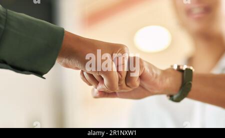 Einander auf sichere Weise begrüßen. Zwei Geschäftsfrauen schlagen sich in der Begrüßung gegenseitig die Faust. Stockfoto