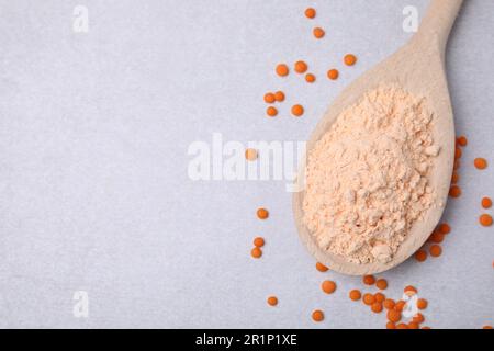 Löffel Linsenmehl und Samen auf weißem Tisch, flach liegend. Platz für Text Stockfoto