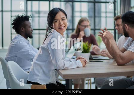Multiethnische Geschäftspartner treffen sich mit Laptops am Tisch im modernen Büro Stockfoto