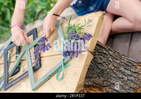 Einfache Ideen für Blumenbilder im Rahmen auf dem Tisch im Garten Stockfoto