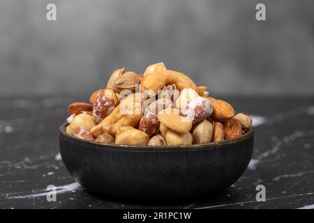 Gemischte Nüsse. Speziell gemischte Nüsse in der Schüssel. Haselnuss, Mandel, Cashew, Pistazien, getrocknete Heidelbeere. Superfood. Vegetarisches Speisenkonzept. Gesunde Snacks. Clos Stockfoto