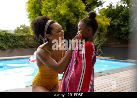 Glückliche afroamerikanische Mutter trocknete Tochter nach dem Schwimmen im Pool Stockfoto